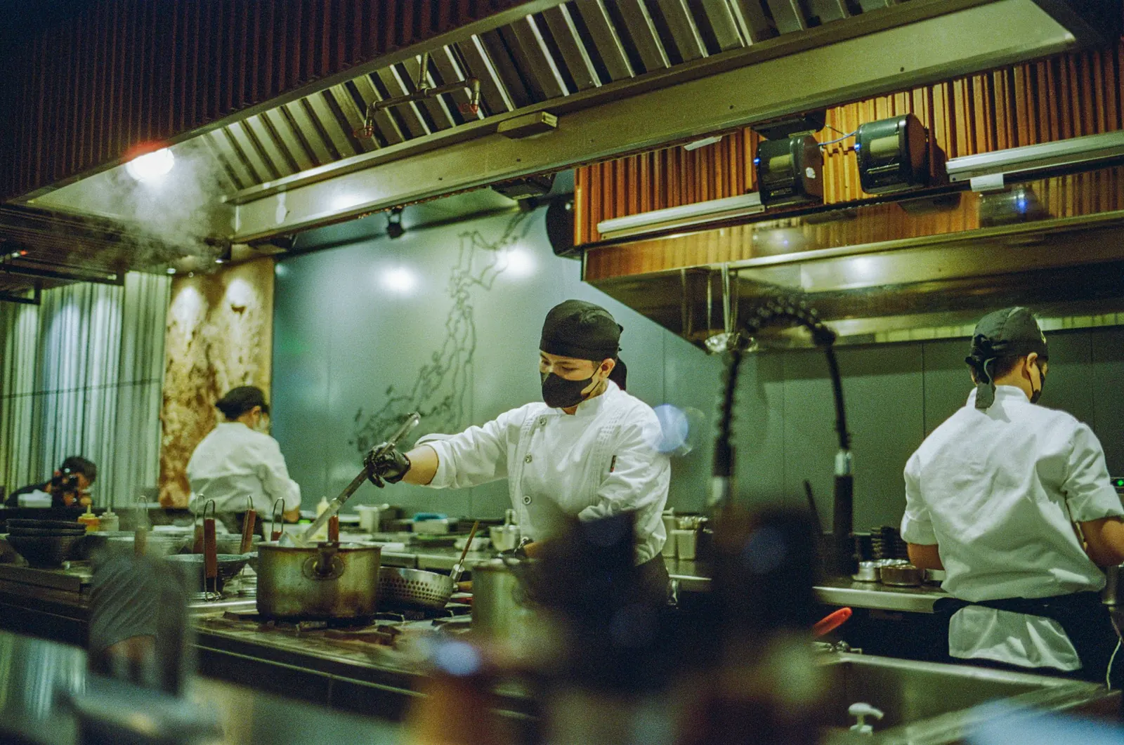 Chefs working together on a busy restaurant kitchen line