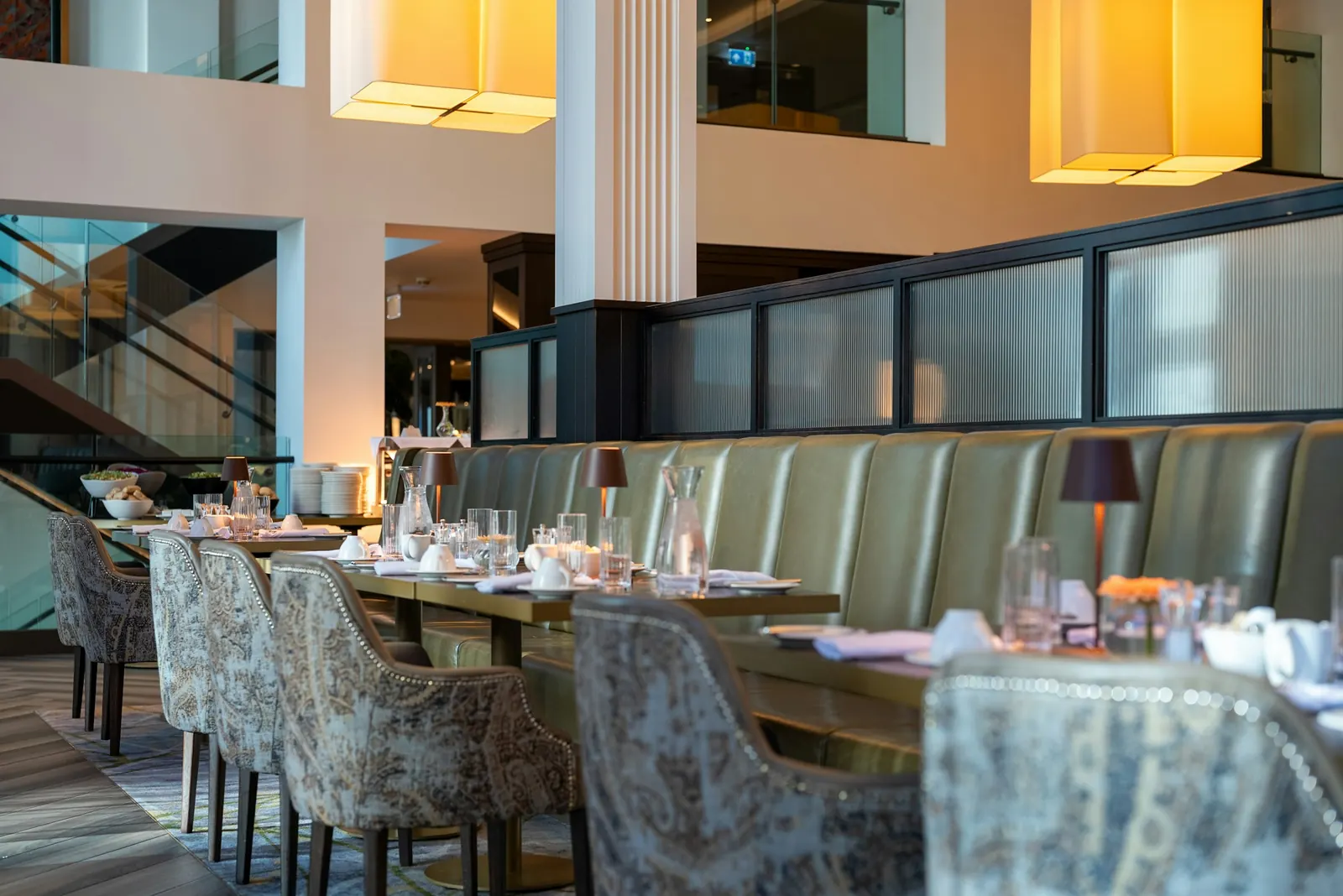 Busy multi-level restaurant dining room with banquette seating
